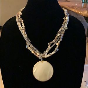 Gold strand necklace with the shell pendant